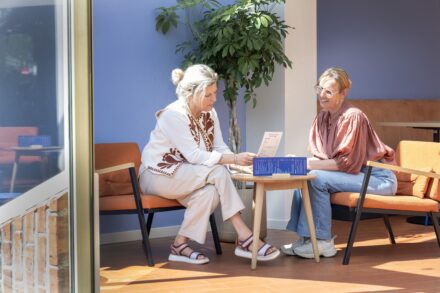 Twee vrouwen bekijken de menukaart van Brasserie Röling bij Drents Museum De Buitenplaats.
