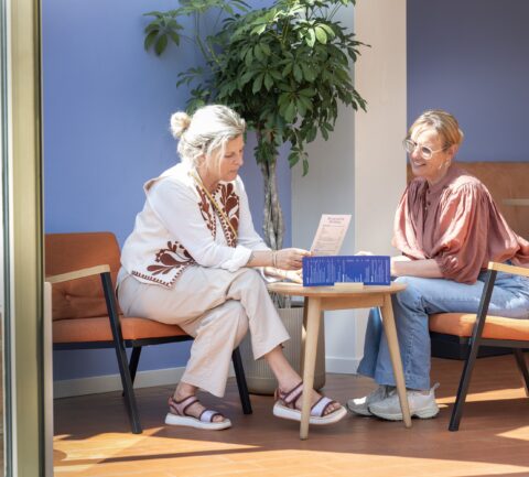 Twee vrouwen bekijken de menukaart van Brasserie Röling bij Drents Museum De Buitenplaats.