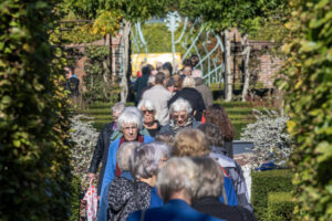 Een stroom van mensen loopt door de museumtuin